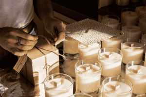 Natural Soy Candles Being Handcrafted And Gift-Wrapped In Glass Jars.