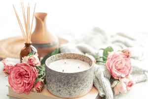 A Cactus Blossom Candle And A Potted Plant On A Wooden Table.