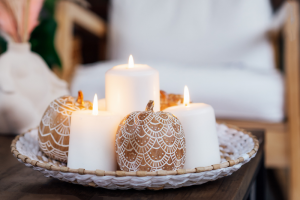 Cozy Candle Setup Featuring White Pillar Candles And Carved Pumpkin-Style Décor, Ideal For Illustrating Candle Care Tips And Home Ambiance.